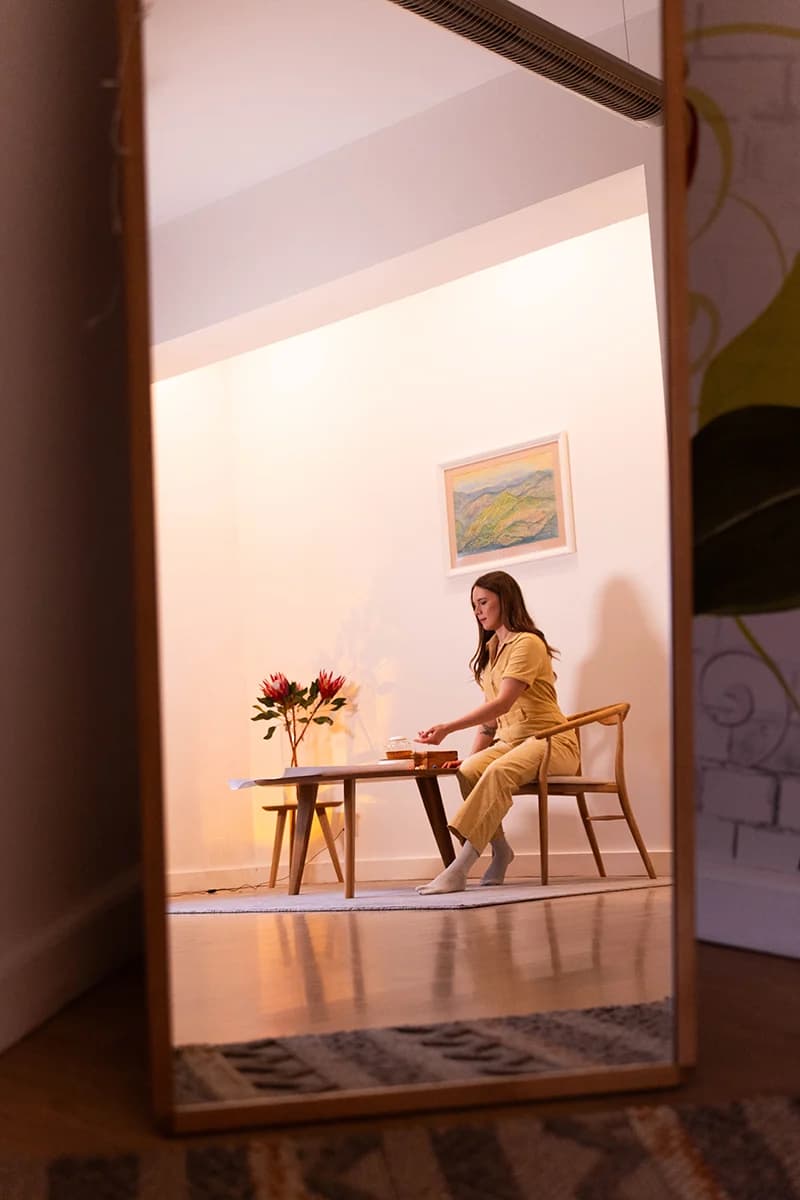 Therapy by Titov therapist Darja Titova in a cosy studio sitting at a low table with flowers, preparing a calm space for an undisturbed session.